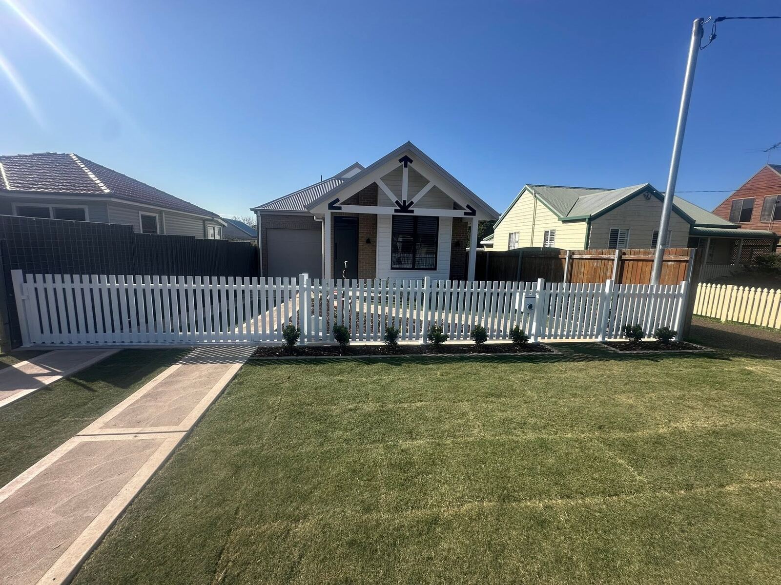 Timber horizontal slat fence beside a brick home