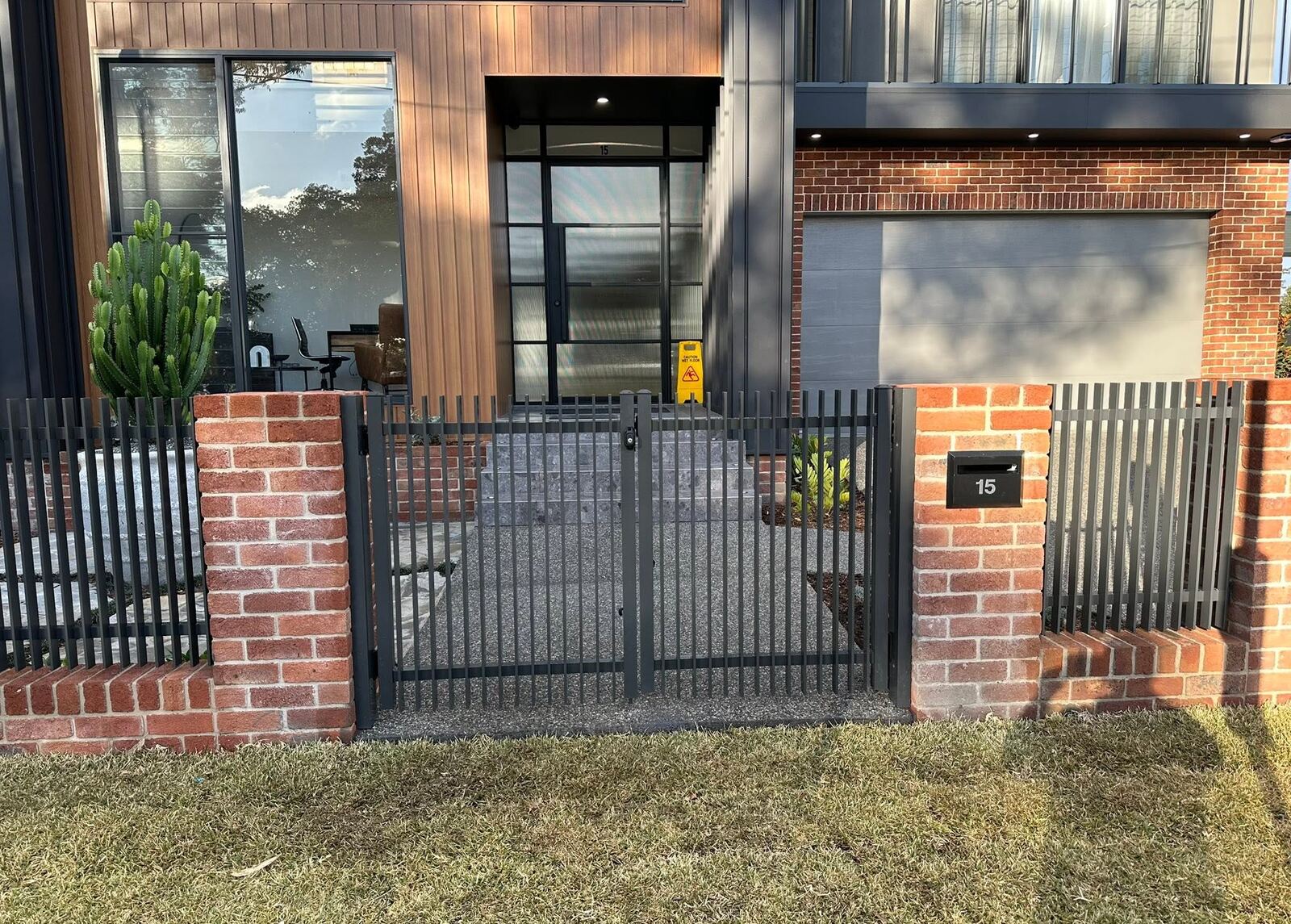 Black aluminium fence and gate at a modern brick home